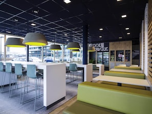 Ein modernes Café mit Barbereich, Sitzgelegenheiten und Blick auf die Straße.