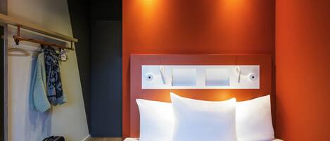 Ein Hotelzimmer mit einem Bett, einer Kamera und einem Koffer.