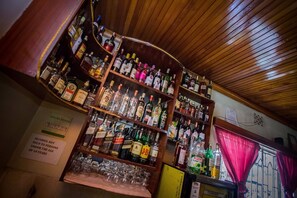 Un bar avec de nombreuses étagères remplies de bouteilles d’alcool et de verres.