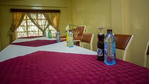 Une chambre d’hôtel avec un lit, une table avec des boissons et une fenêtre avec des rideaux.