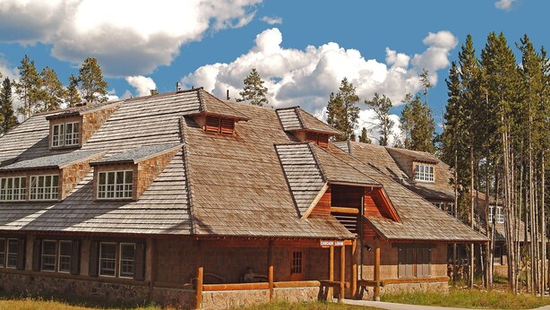 A log cabin with a steep roof, wooden exterior, and a stone foundation.