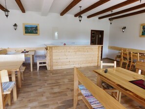 A wooden interior with a reception desk, benches, and tables. - House Sara 2 (Rakovica)