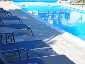 A swimming pool with lounge chairs and a covered area. - House Sara 2 (Rakovica)