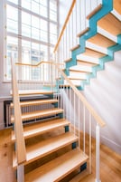 Una escalera de madera con barandillas blancas y una pared de acento azul.