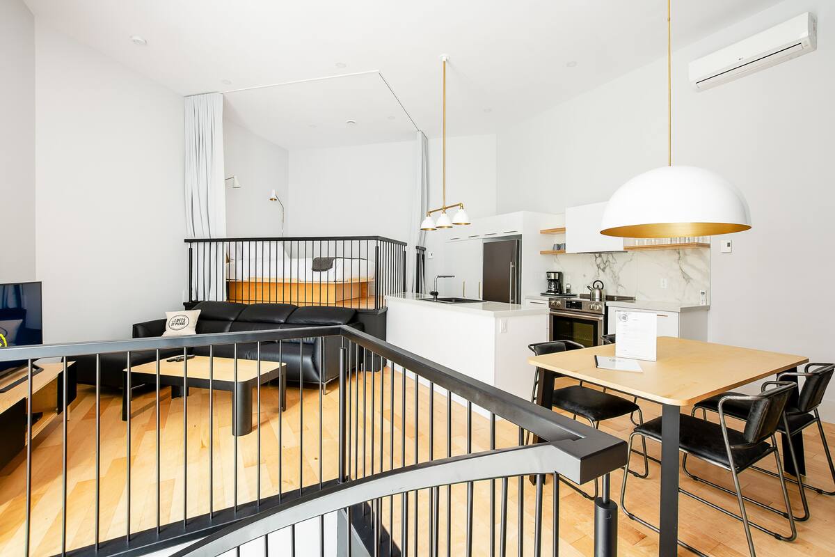 A modern apartment with a kitchen, dining area, and living room.
