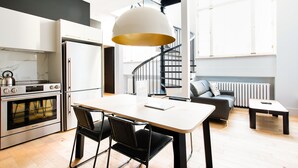 A modern kitchen with a built-in oven and a dining area with a table and chairs.