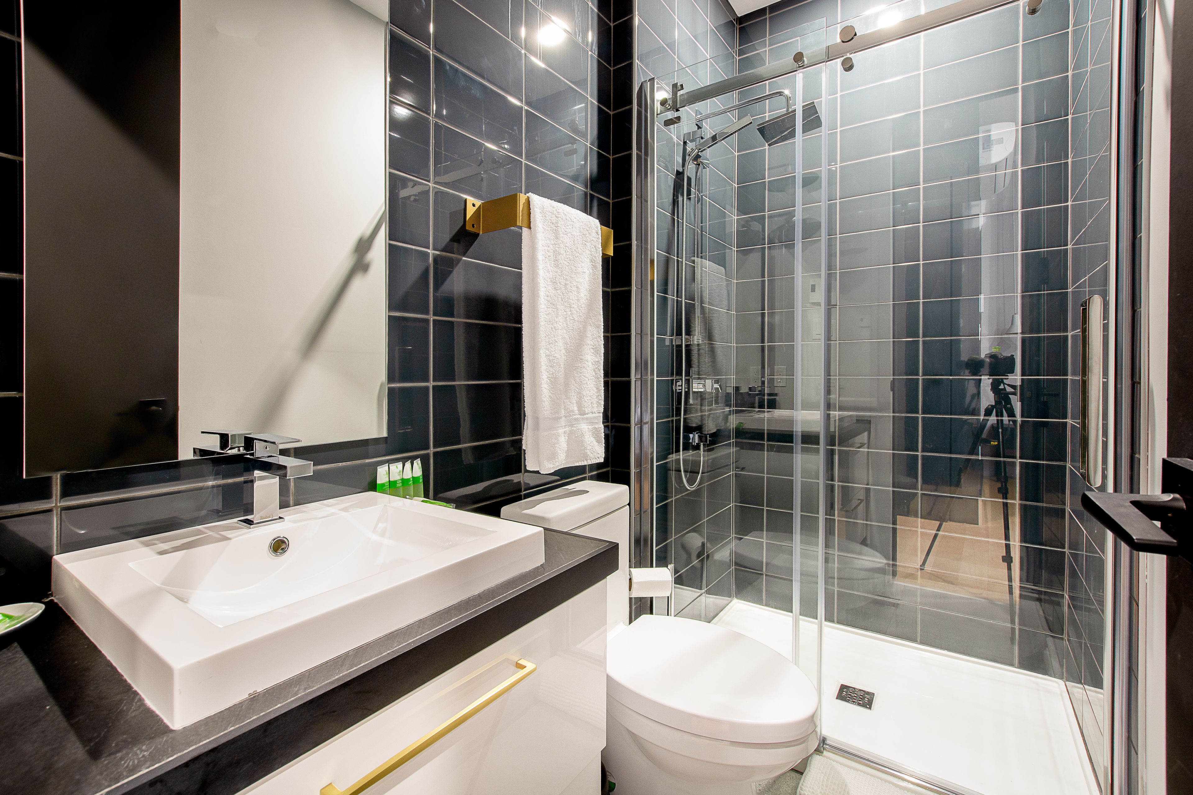 Une salle de bain moderne avec un grand lavabo blanc, des toilettes et une douche à parois de verre.