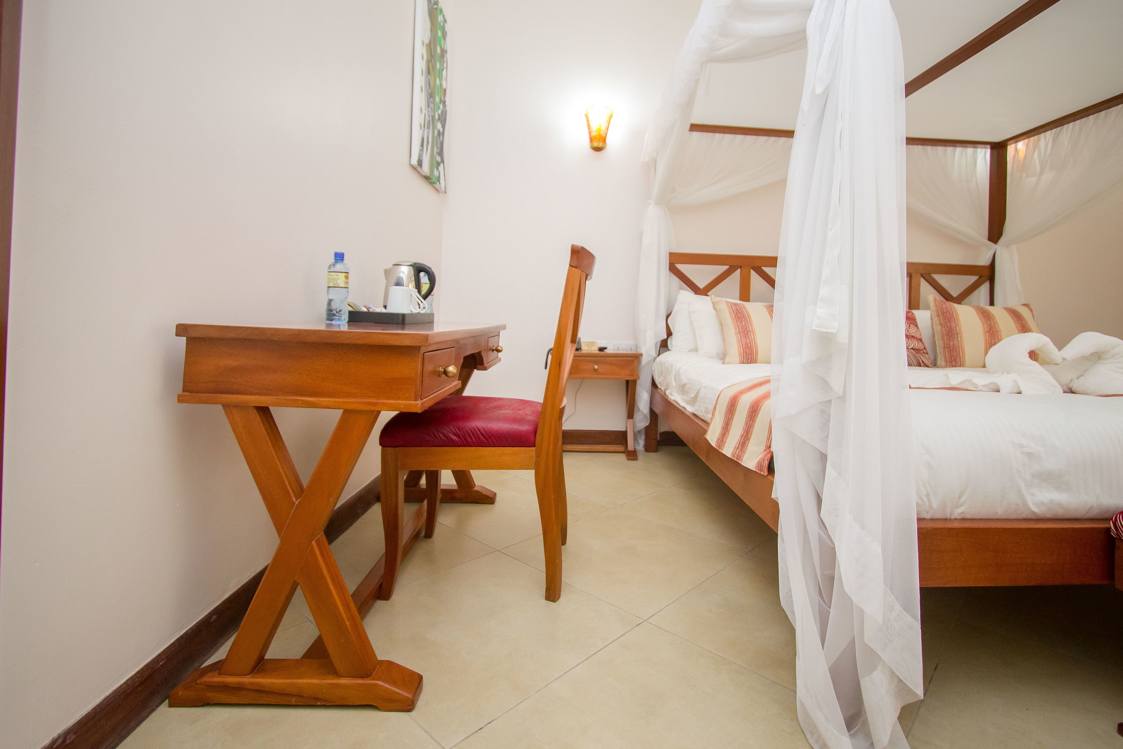 A bedroom with a wooden bed, a desk, and a chair.