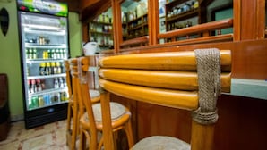 Un espace bar avec des chaises en bois et un comptoir.