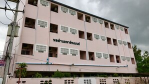 A multi-story building with several open windows and balconies, featuring a sign in a non-English script. - Ponlaan Apartment (Nakhon Ratchasima)