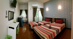 Una camera d'albergo con due letti, una scrivania, una sedia e un tavolino.