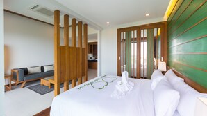A modern hotel room with a bed, a sofa, a wooden partition, and a green accent wall. - Andakiri Pool Villa Panoramic Sea View (Krabi)
