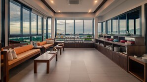 A spacious room with large windows, a seating area with sofas and tables, and a kitchen area with shelves and appliances. - Andakiri Pool Villa Panoramic Sea View (Krabi)