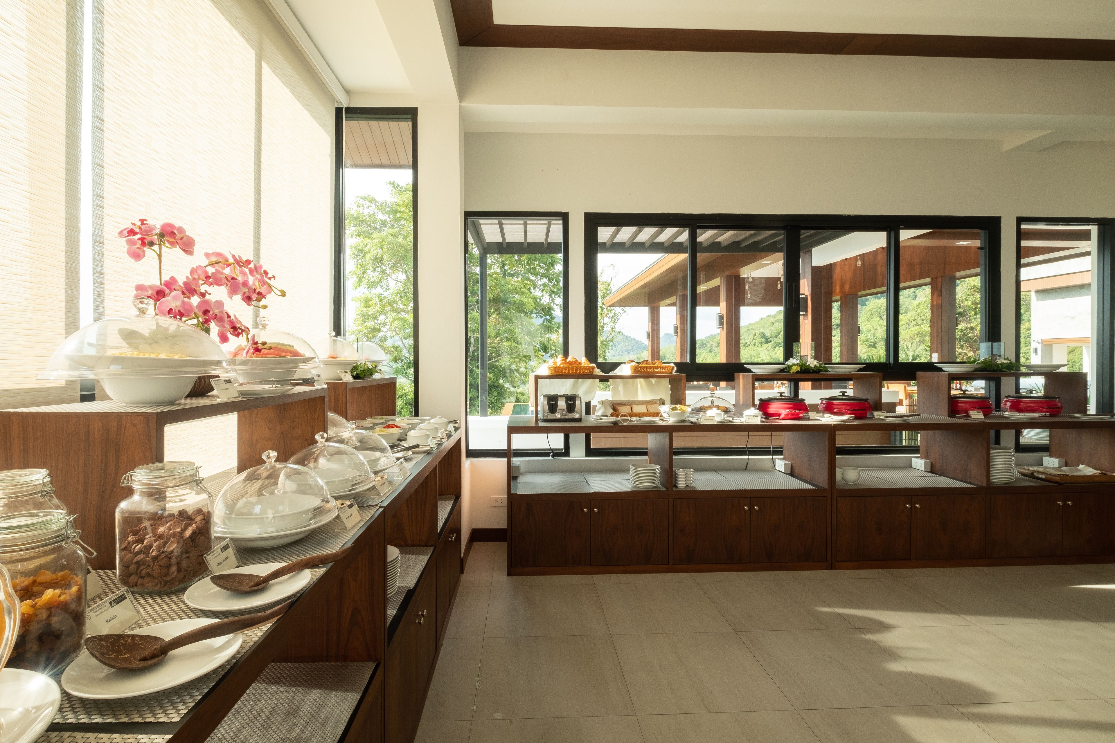 A breakfast buffet with various food items and a view of the outdoors.