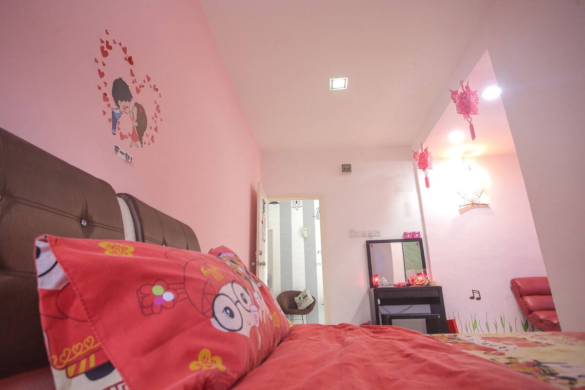A bedroom with a bed, a chair, a desk, and a mirror.