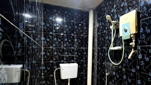 A bathroom with a toilet, a shower, and a sink.