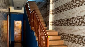 A staircase with wooden railings and patterned wall tiles.