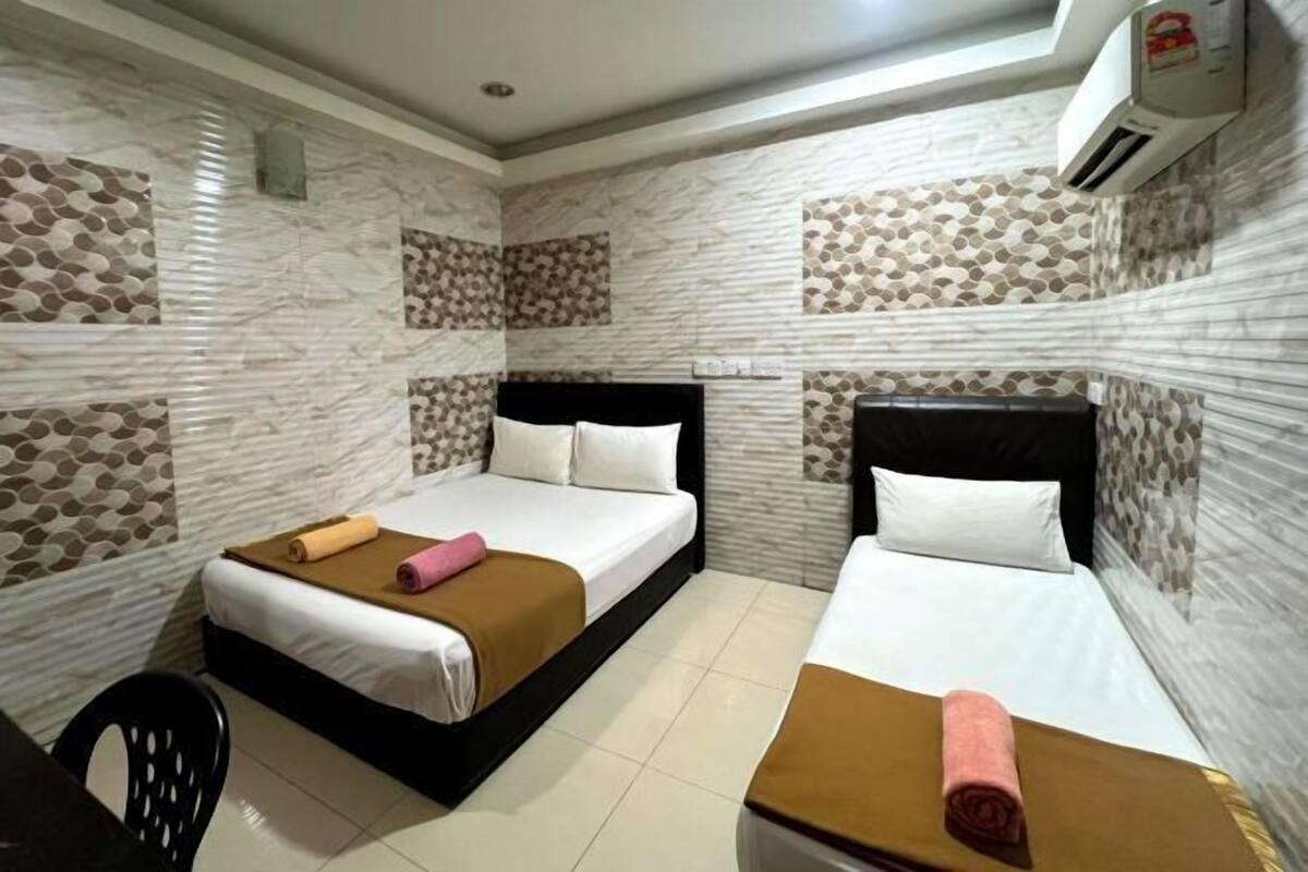 Camera d'albergo con due letti, una scrivania e un condizionatore d'aria.