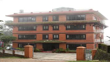 A multi-story brick building with a flat roof and a sign for 'Sunshine Hotel'.