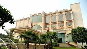 A large, two-story building with a beige facade and arched windows. The name "EQUAL INN" is displayed above the entrance.