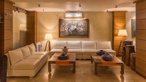 A modern living room with a sofa, two coffee tables, and a painting on the wall. - Sangai Continental The Boutique Hotel (Imphal)