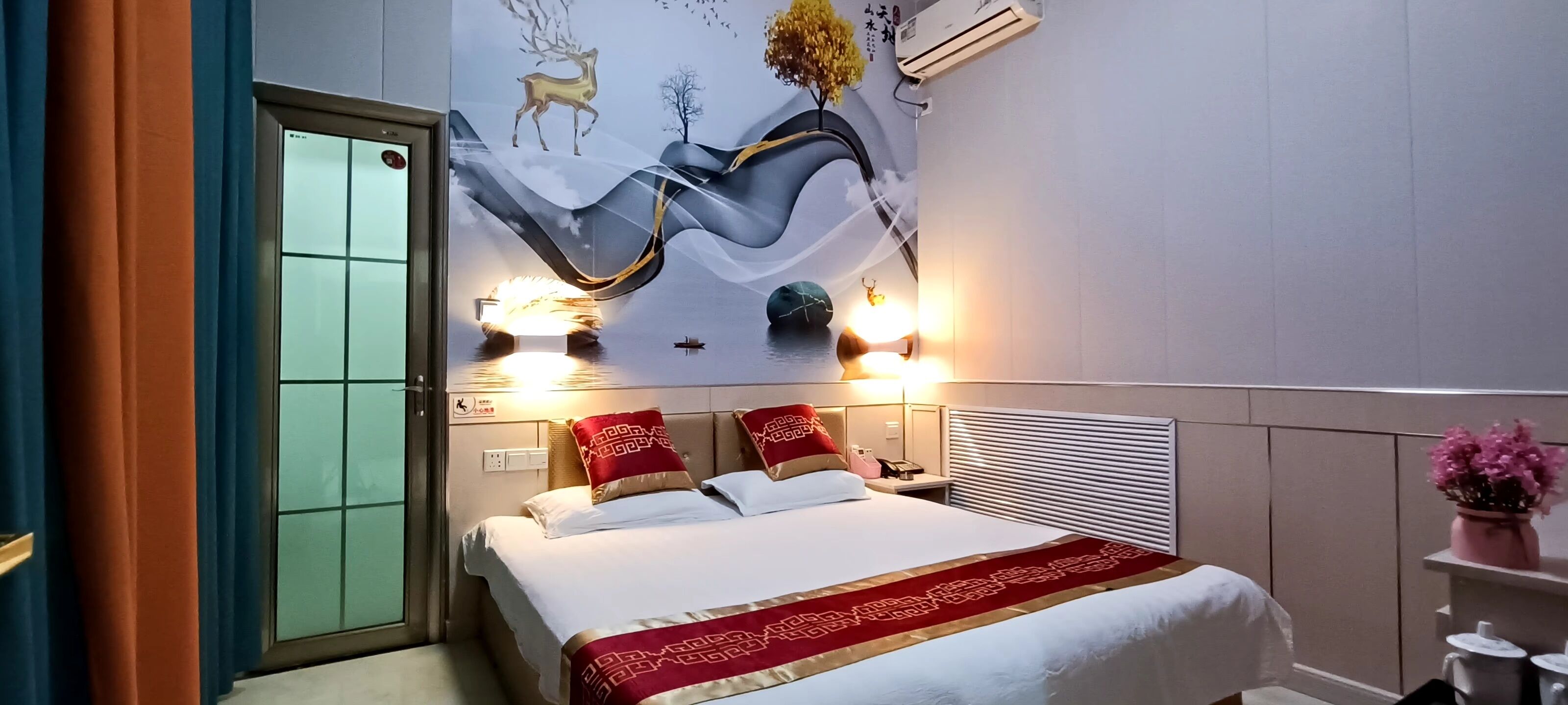 Une chambre d’hôtel avec un lit, une fresque murale et une fenêtre.