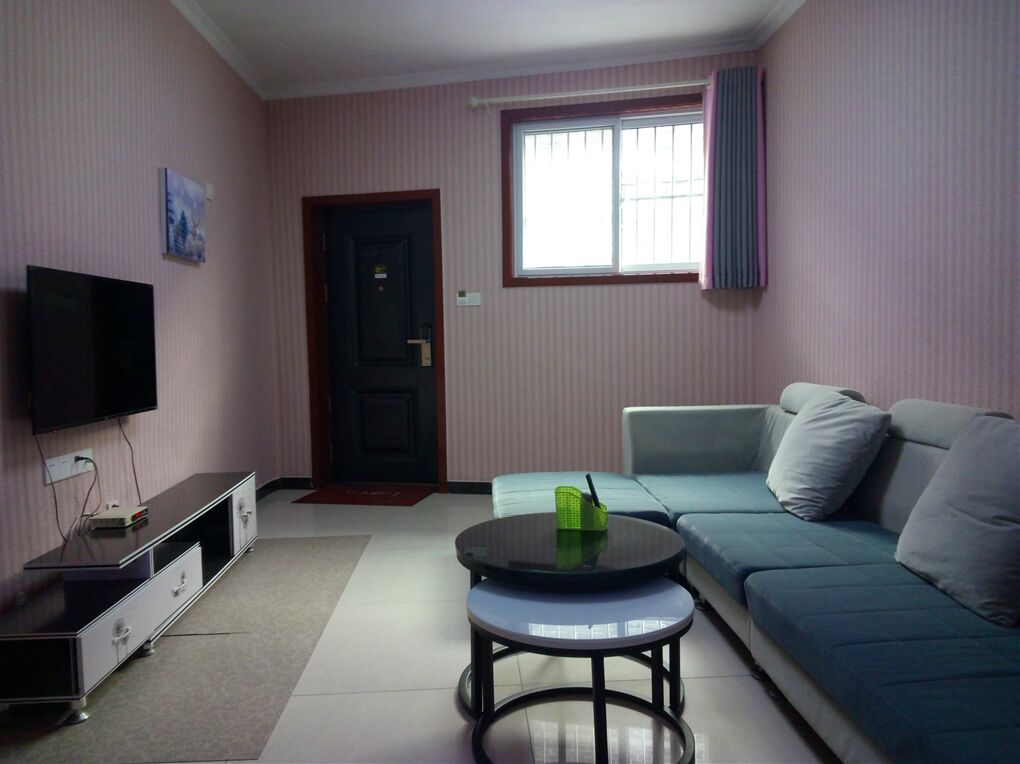 Ein Wohnzimmer mit Fernseher, Sofa und Couchtisch.