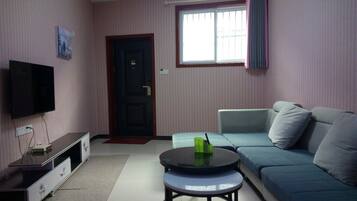 Ein Wohnzimmer mit Fernseher, Sofa und Couchtisch.