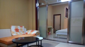 Una habitación de hotel con sofá, una mesa redonda y una cama.