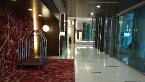 A hotel corridor with a red carpet, metal railings, and a glass wall on one side. - Queens Service Suite at Swiss Garden Residences (Kuala Lumpur)