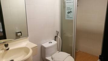 Un baño con lavabo, inodoro y cabina de ducha de vidrio.