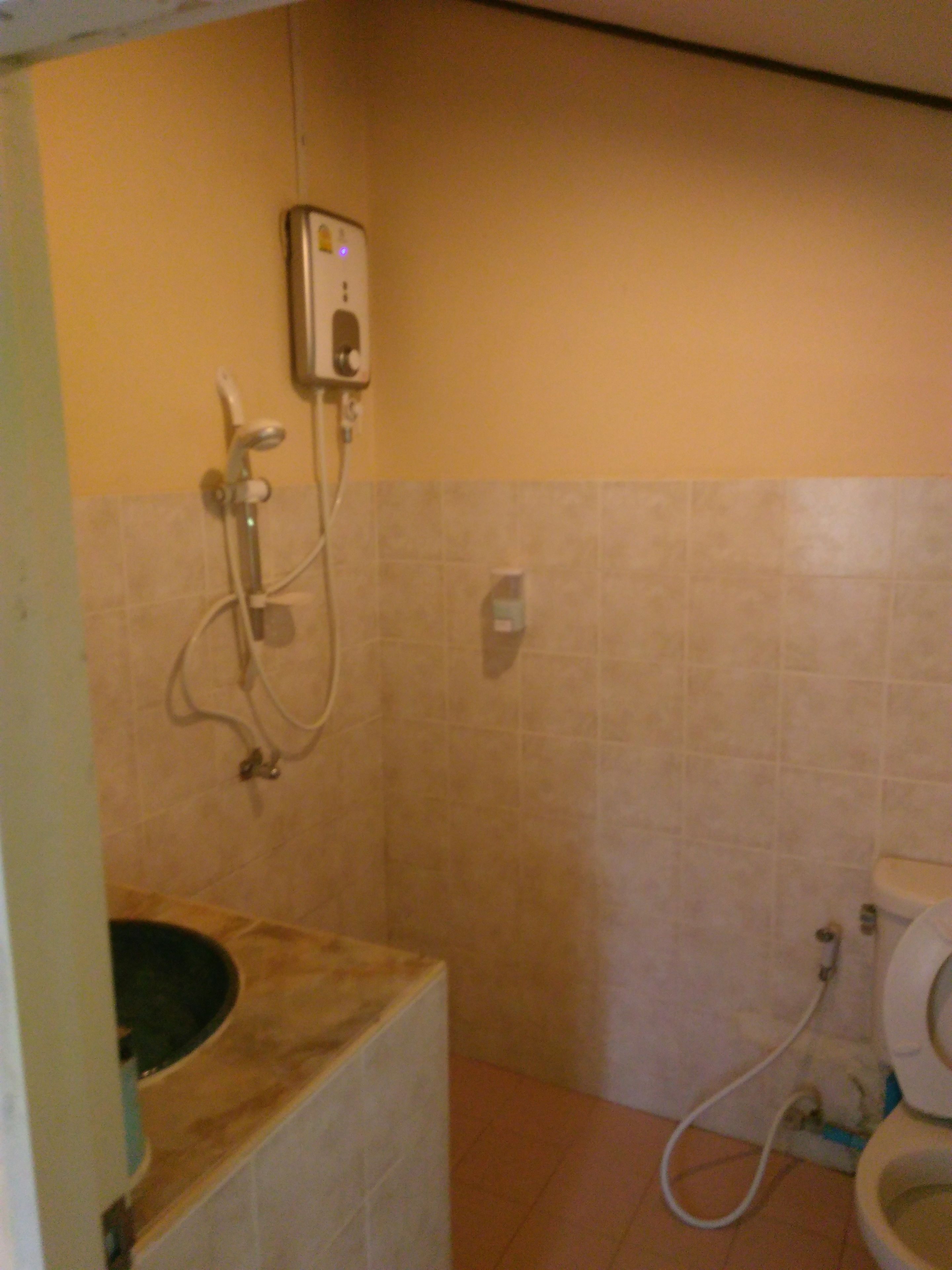 A bathroom with a shower, toilet, and sink.