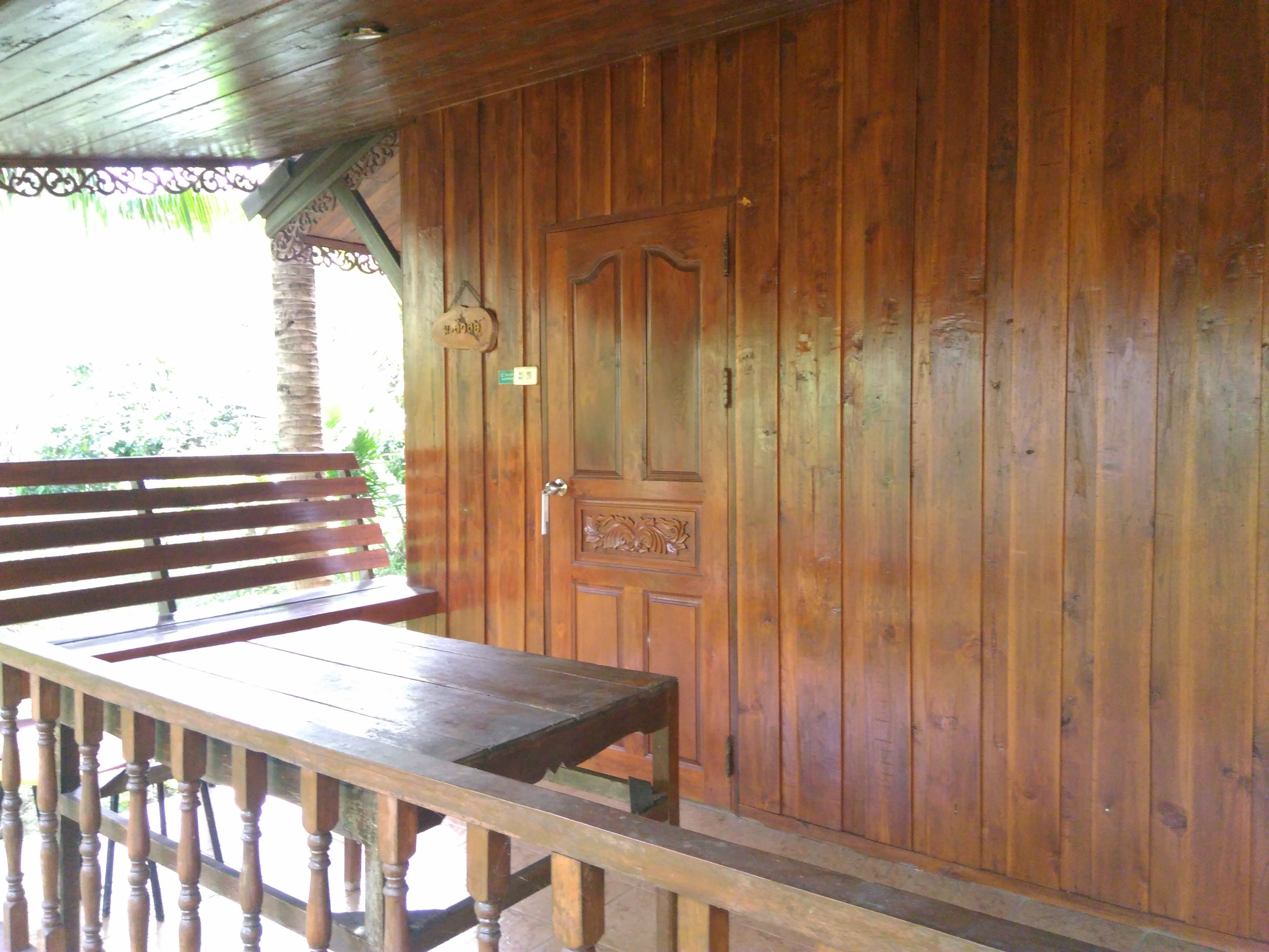 A wooden cabin with a bench and a door.