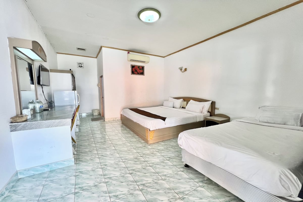 Ein Hotelzimmer mit Bett, Schreibtisch, Stuhl und Fernseher.