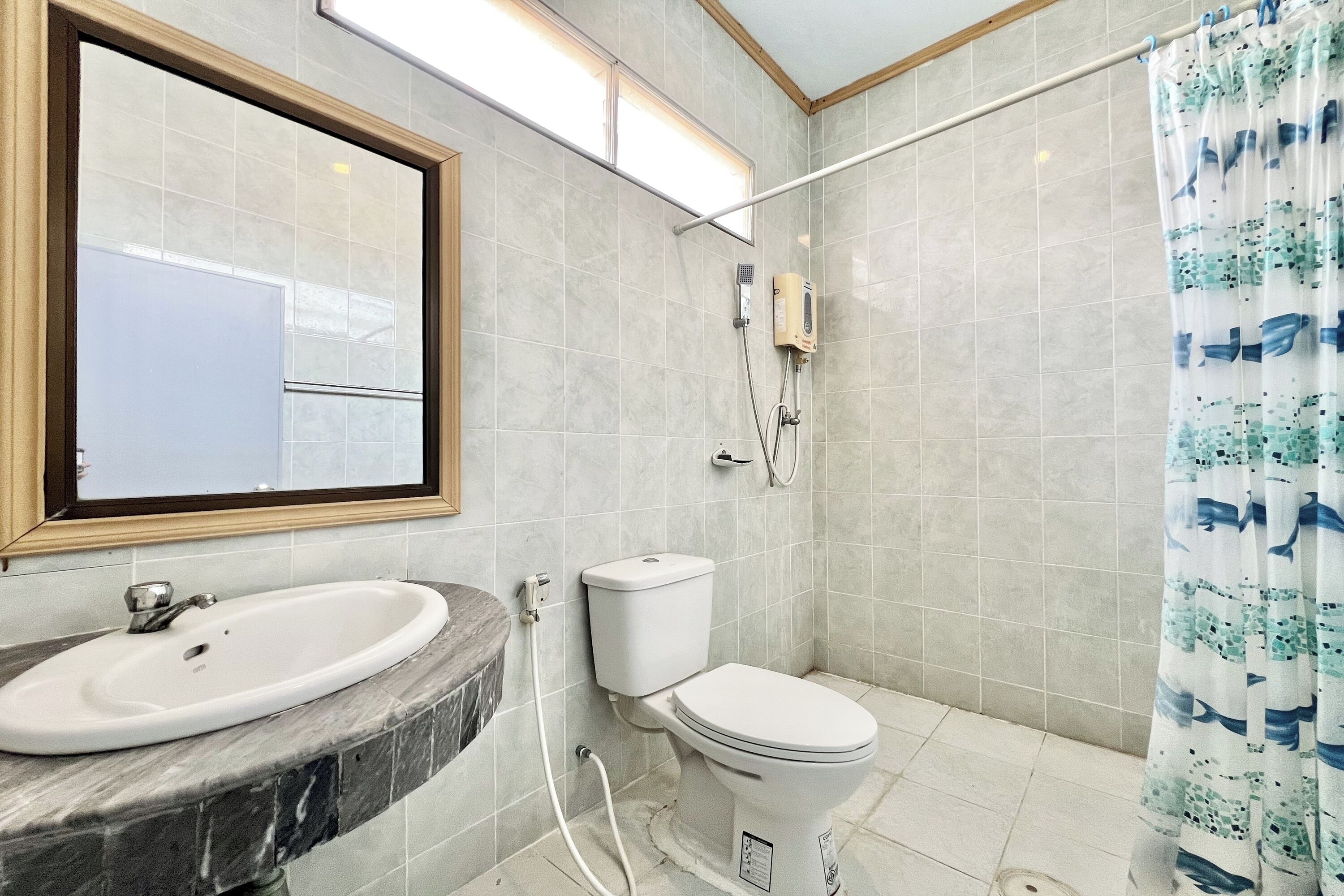 A bathroom with a marble sink, a toilet, and a shower curtain.
