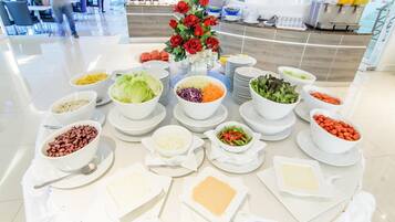 Una mesa de buffet con diferentes platillos y un centro de rosas rojas.