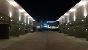 A parking garage with multiple levels and illuminated entry points. - Heaven Inn (Si Racha)