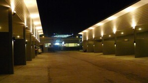 A nighttime view of a parking garage with multiple levels and rows of parking spaces. - Heaven Inn (Si Racha)