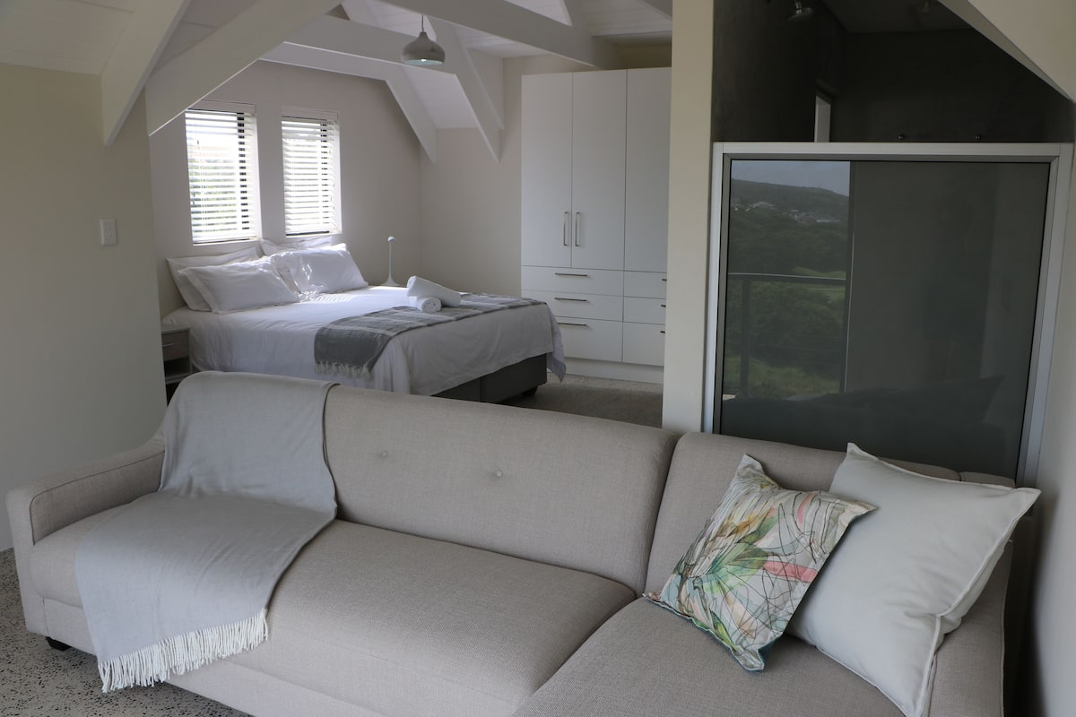Une chambre à coucher avec un lit, un canapé et une armoire.