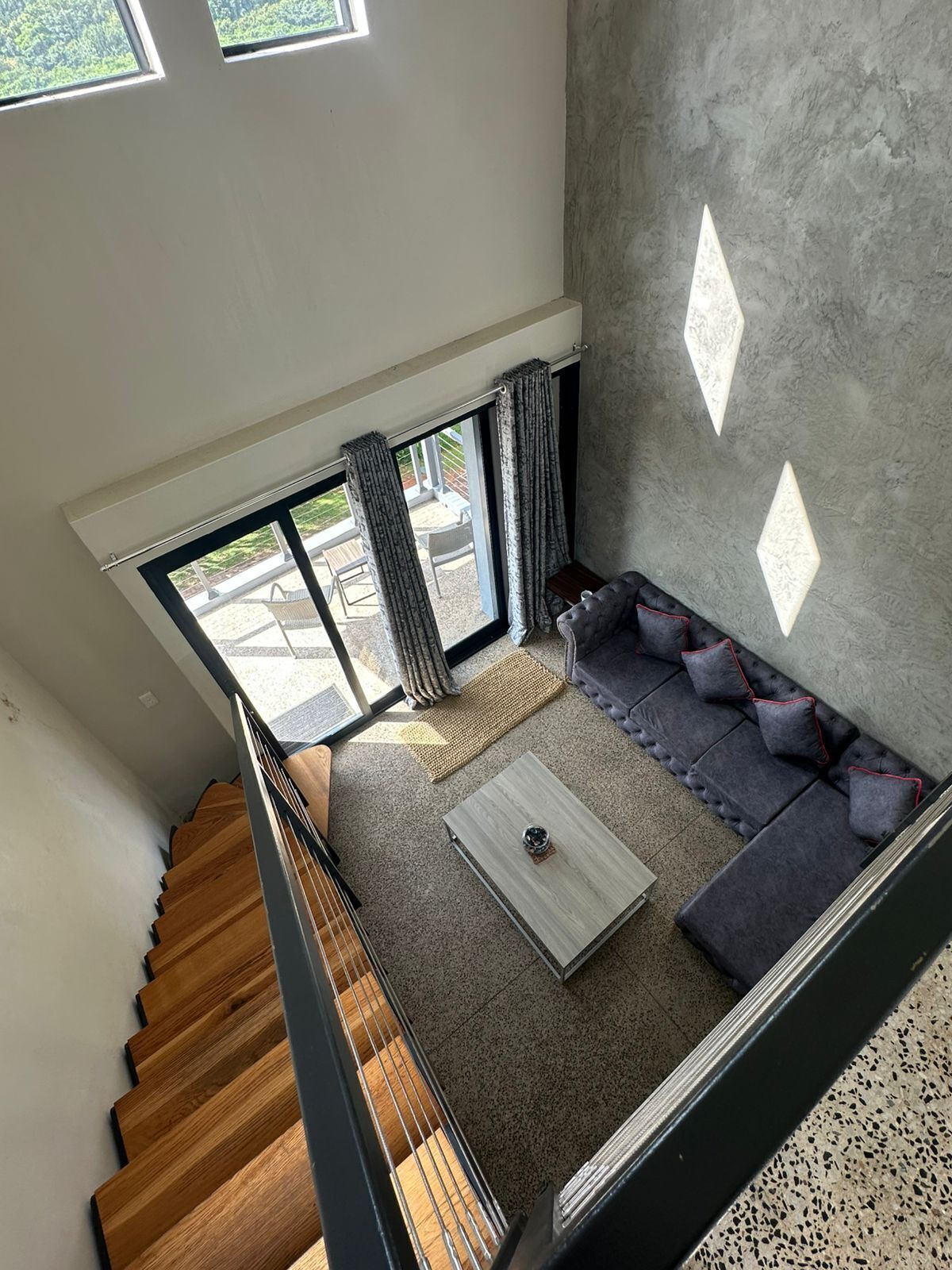 A spacious living area with a staircase, a sofa set, and a coffee table.