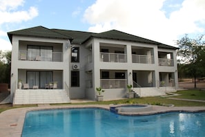 A two-story building with a swimming pool, balconies, and a covered patio area. - Tinyiko Kruger Lodge (Nkomazi)