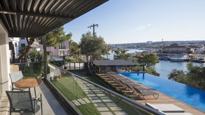 A balcony with a view of a marina and a swimming pool. - Kubana Hotel (Cesme)