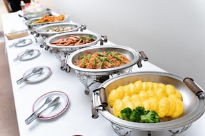 Enjoy a sumptuous spread of international cuisine at our buffet, featuring a variety of dishes, including stir-fried vegetables and savory meats.