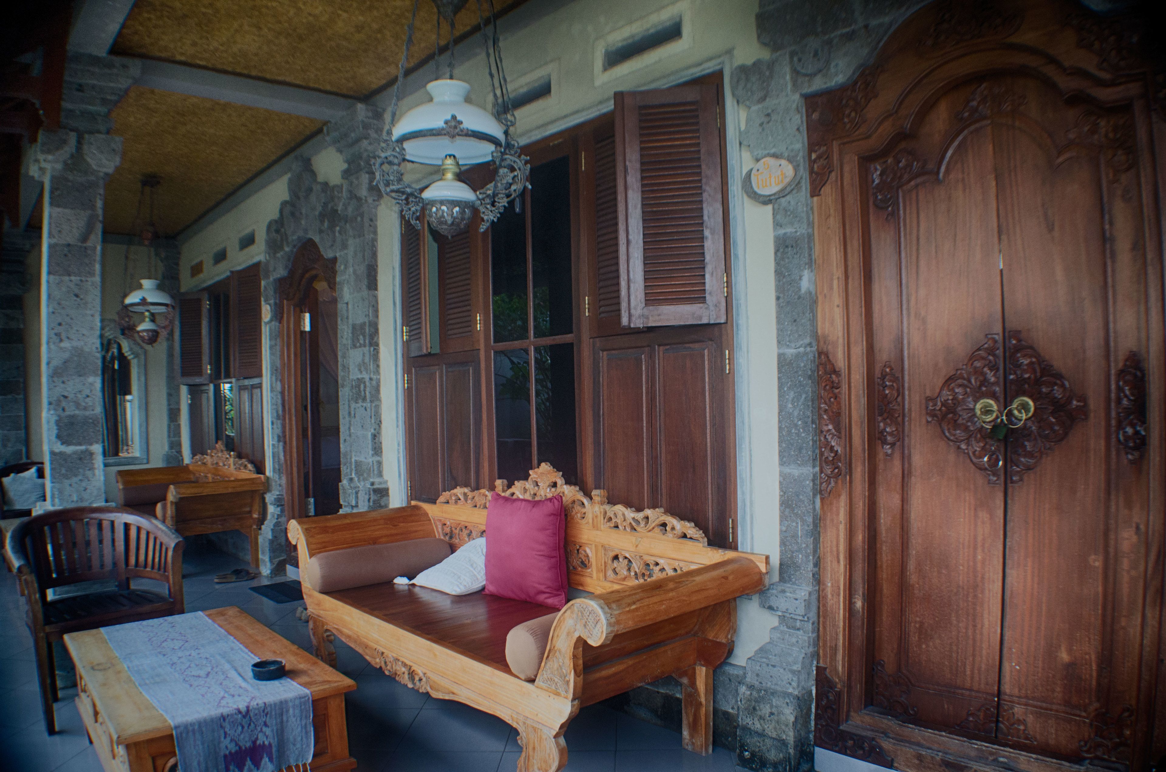 A traditional wooden room with a bench, a table, and a large wooden door.