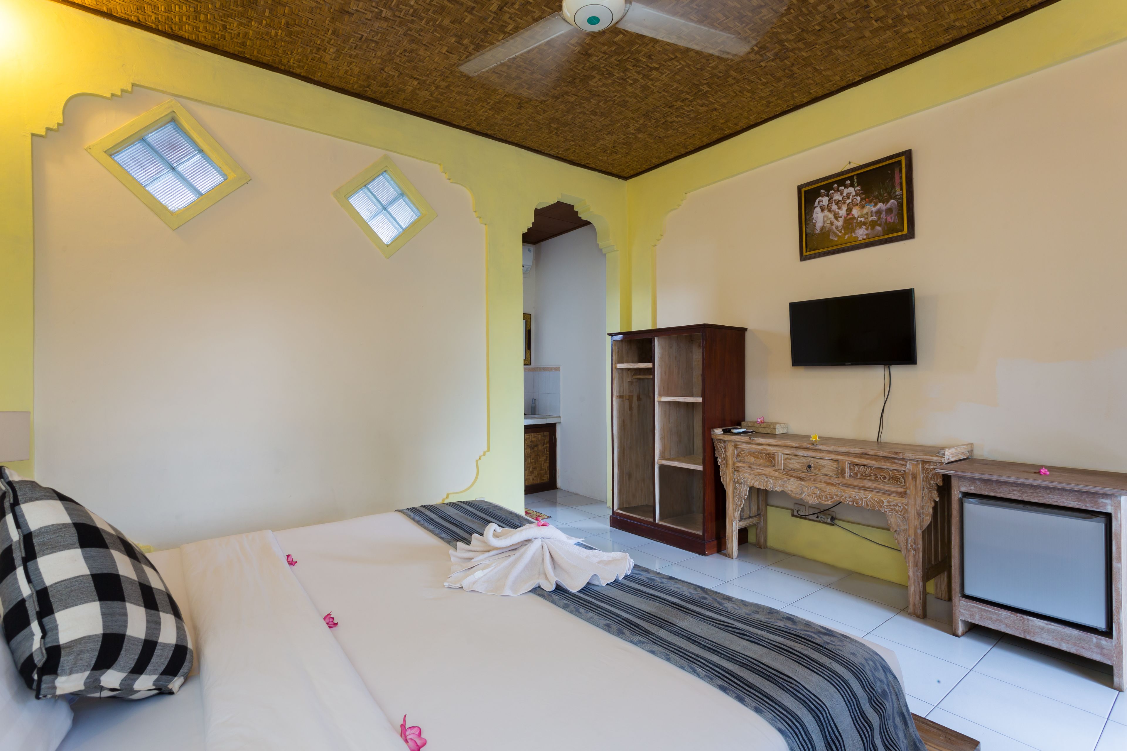 Een hotelkamer met een bed, een bureau, een televisie en een kledingkast.