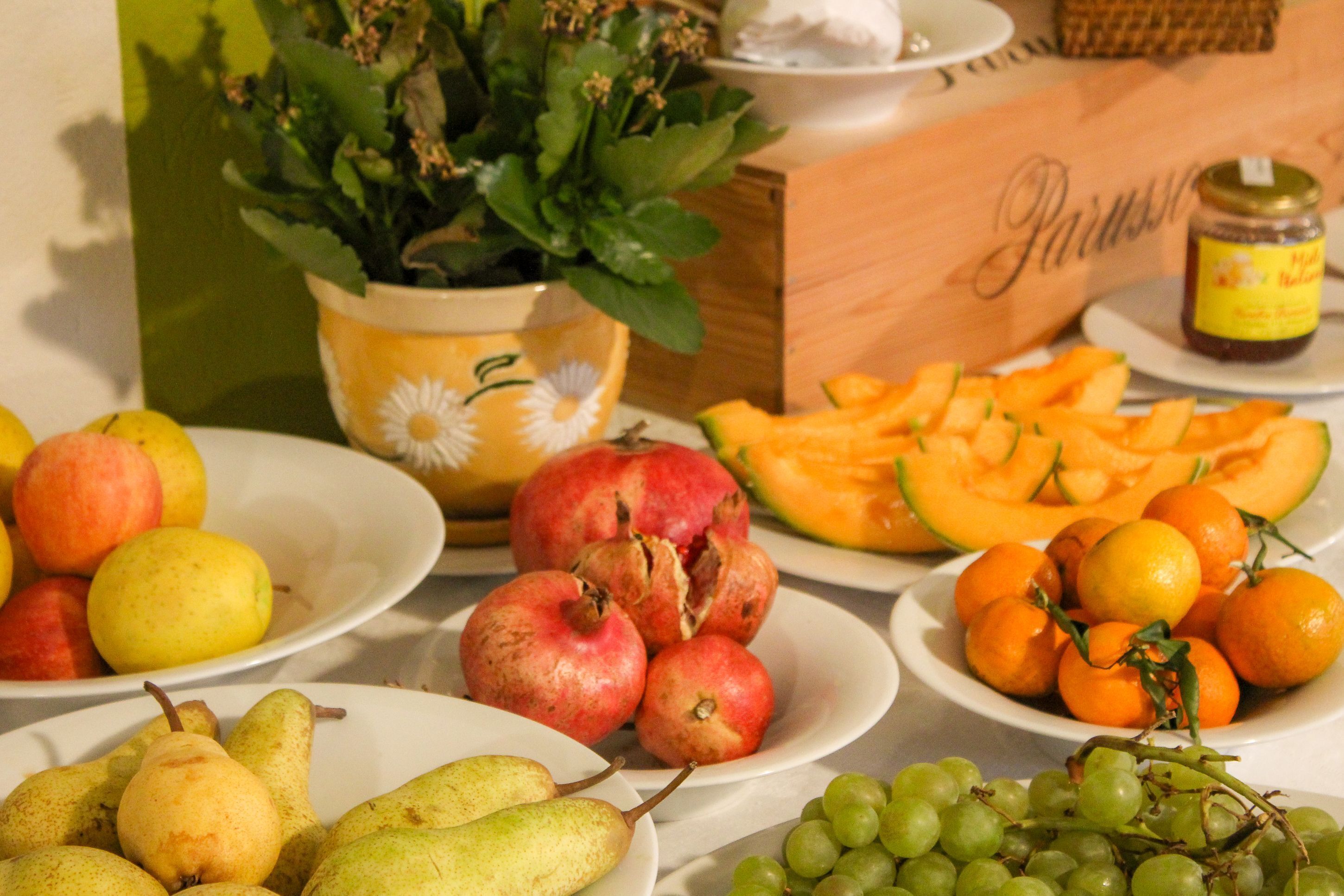 Een tafel met verschillende soorten fruit, zoals appels, peren, sinaasappels en druiven.