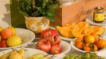 Een tafel met verschillende soorten fruit, zoals appels, peren, sinaasappels en druiven.