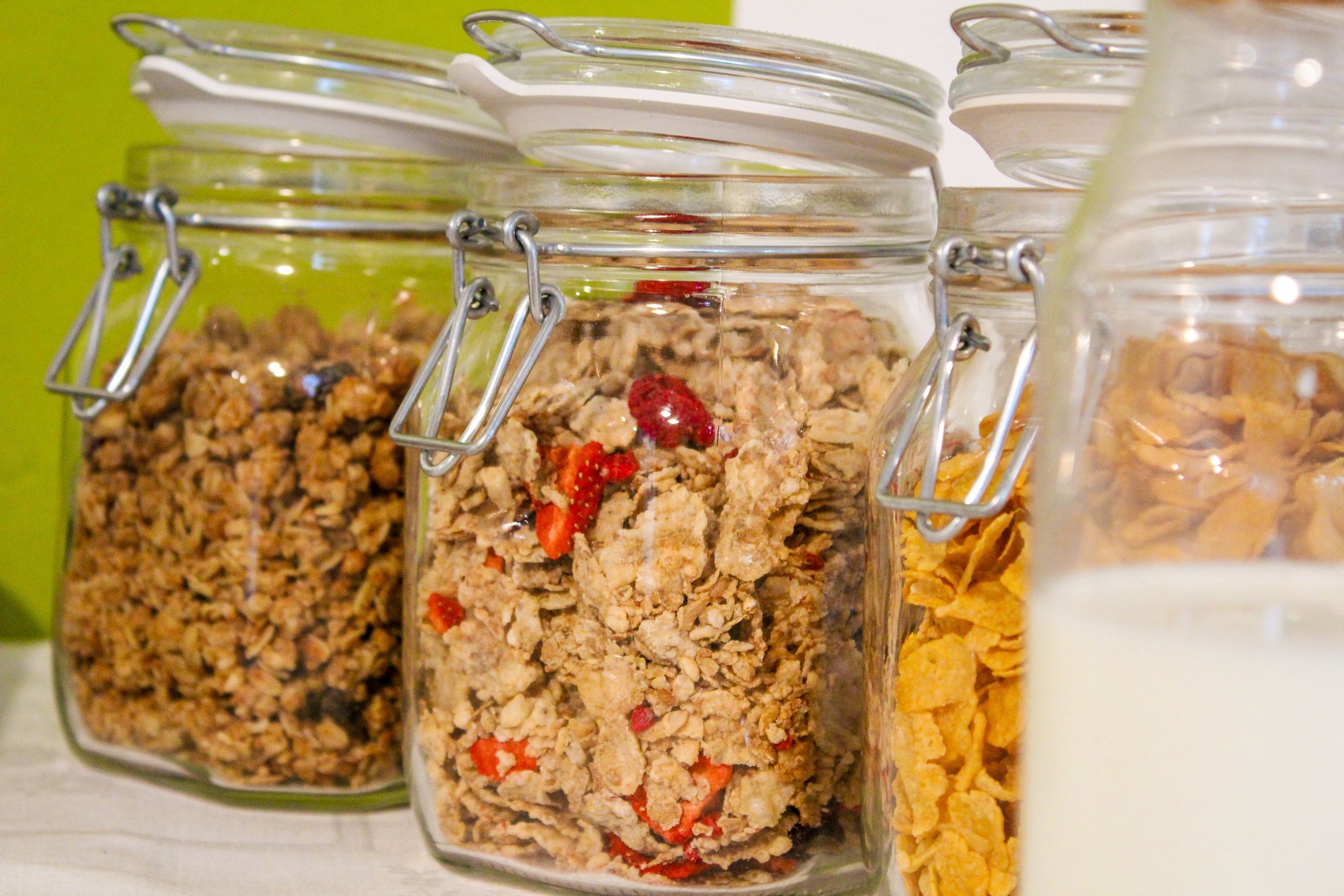 Tres frascos de vidrio con cierres metálicos que contienen diferentes tipos de cereales.