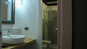 A bathroom with a white sink, a mirror, and a shower with patterned tiles.