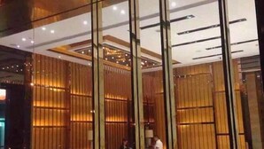 A reception area with a modern design, featuring vertical wooden slats and a glass partition. - Tianguo Xingyue Hotel (Foshan Jiazhou Plaza) (Foshan)